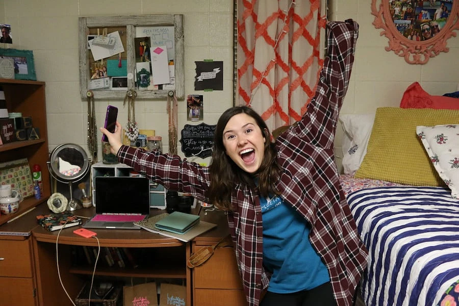 Student celebrating in residence hall room